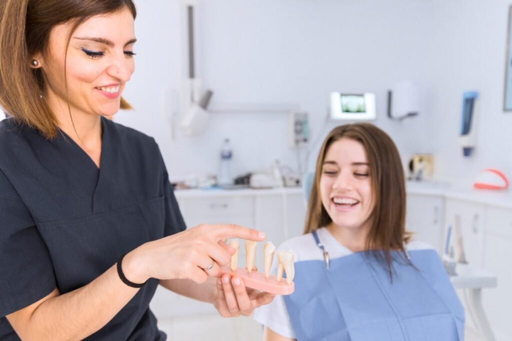 Dentist explaining dental implant options to a patient using a tooth model