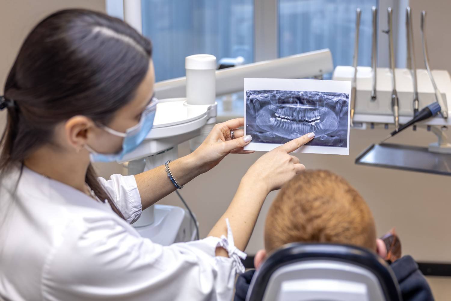 Dentist showing a dental X-ray to a patient during treatment