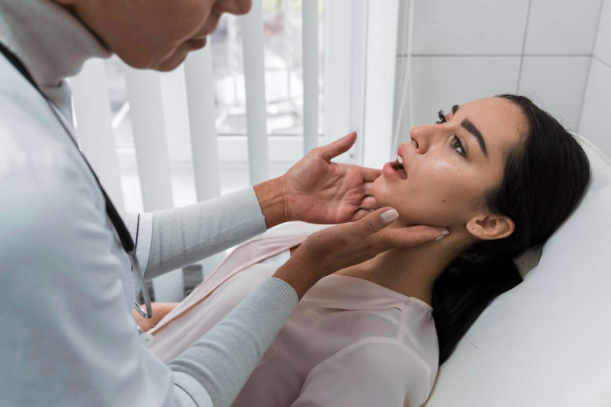 Dentist examining a female patient’s jaw and oral health during a dental checkup in a modern dental clinic.