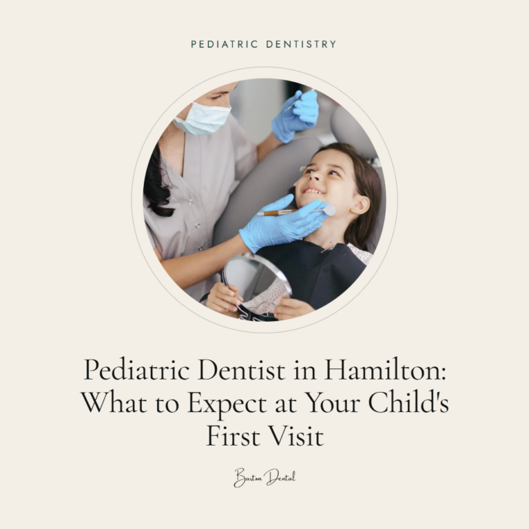 Dentist examining smiling young girl holding a hand mirror in dental chair - what to expect at your child's first pediatric dental visit in Hamilton, Barton Dental